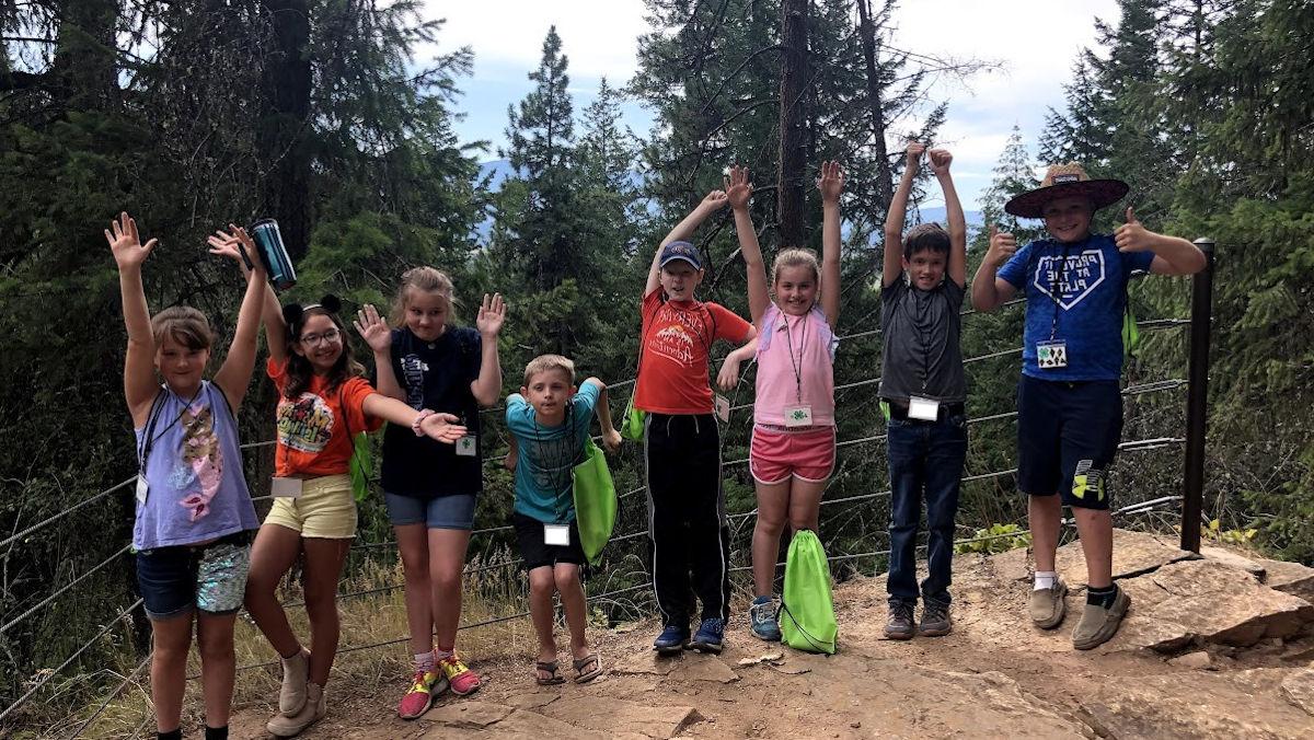 Several children pose on a hiking trail.